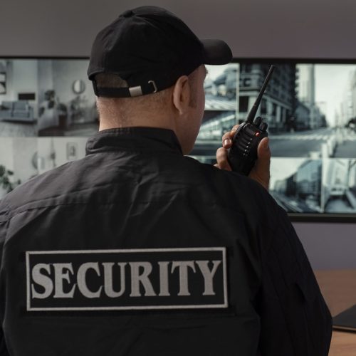 portrait male security guard with radio station camera screens (1) (1)