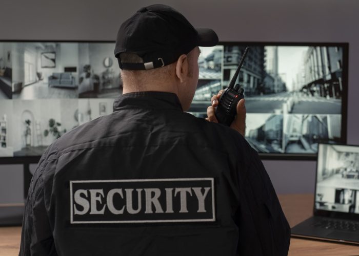 portrait male security guard with radio station camera screens (1) (1)